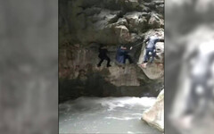 張家界遊客徒手攀岩險落水 工作人員：有安全員「一般不會掉下去」